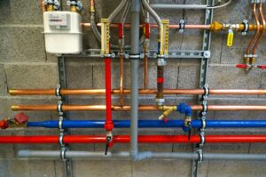 color metal pipes on cinderblock wall