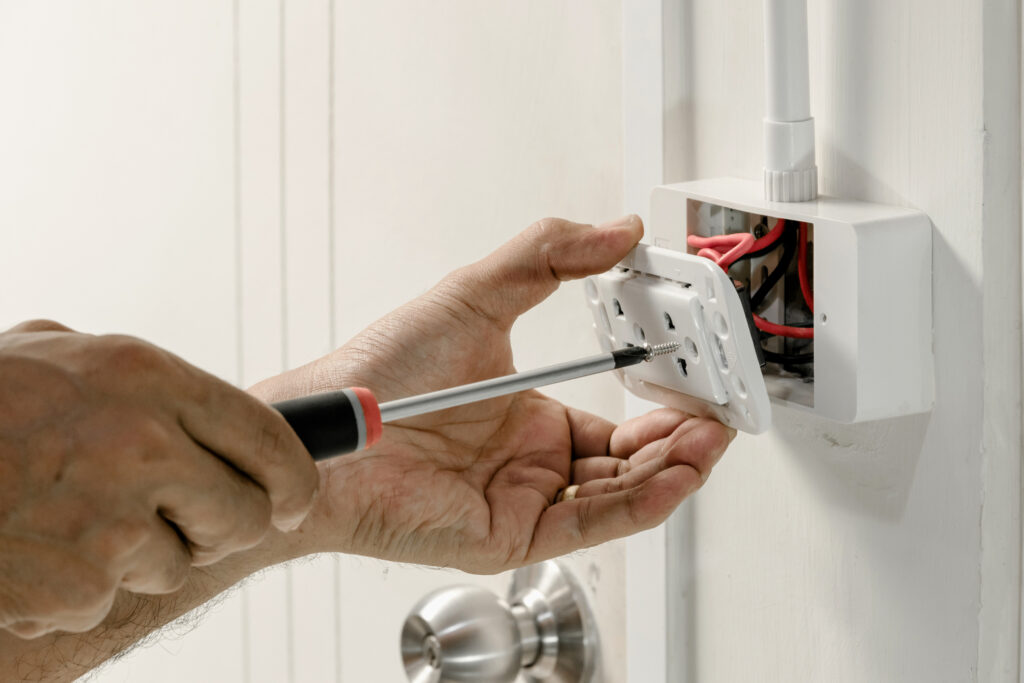 electrician repairing a GFCI outlet