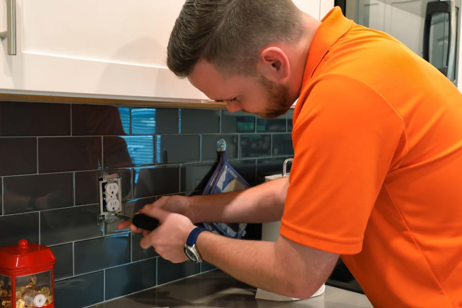 Electrician installing childproof outlet.