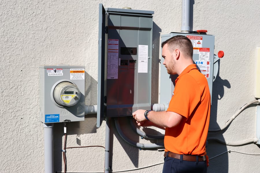 Mac 5 electrician conducting electrical repairs and troubleshooting on the side of the house.