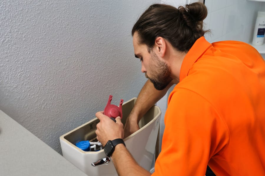 Mac 5 plumber repairing a broken toilet.