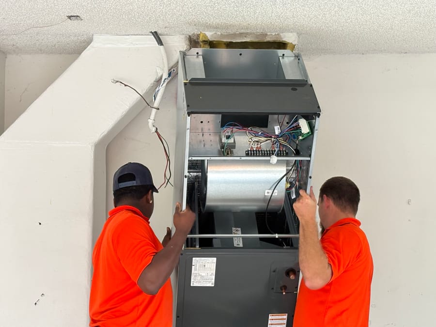 Mac 5 technicians installing a furnace.