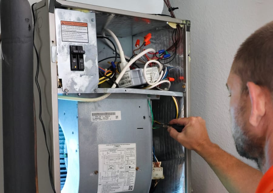 Technician repairing furnace or heater.