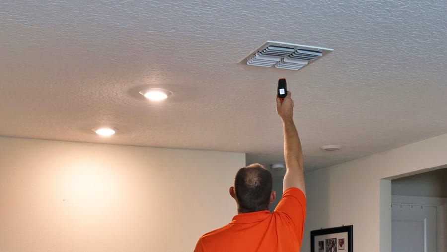 Mac 5 technician testing air in the vents in the ceiling.