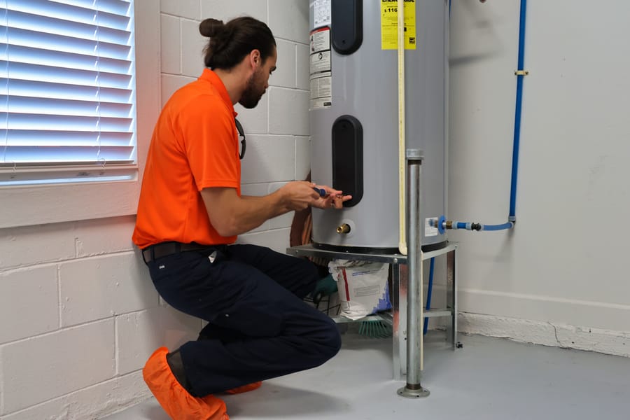 Mac 5 plumber servicing a water heater in the basement.